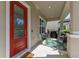Inviting front porch with outdoor seating, a red front door and a charming welcome mat at 9348 Meadow Hunt Way, Winter Garden, FL 34787