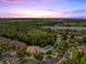 Sunset aerial view of a community's pool, lake, amenities, and the surrounding lush greenery at 9559 Silver Buttonwood St, Orlando, FL 32832