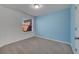 Bright bedroom with a large window and neutral carpeting with blue accent wall paint at 9559 Silver Buttonwood St, Orlando, FL 32832