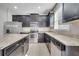 Modern kitchen featuring stainless steel appliances, dark cabinets, and granite countertops at 9559 Silver Buttonwood St, Orlando, FL 32832