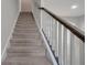 Carpeted staircase with white railings and a dark wood handrail at 9559 Silver Buttonwood St, Orlando, FL 32832