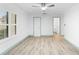A bright bedroom featuring wood floors, a large window, and access to the bathroom at 101 Grand Plaza Dr # P6, Orange City, FL 32763