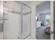Modern bathroom featuring a glass shower with decorative tile and open view to bedroom with view at 10221 Highline Crest St, Orlando, FL 32832