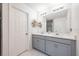 Bathroom featuring double vanity, quartz countertops, large mirror, and bright modern lighting at 10221 Highline Crest St, Orlando, FL 32832