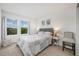 Cozy bedroom with neutral decor, two windows showcasing a serene lake view, and matching floral art at 10221 Highline Crest St, Orlando, FL 32832