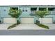 Townhome garages with manicured lawns and trees at 10221 Highline Crest St, Orlando, FL 32832