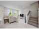 Bright living room boasting white marble floors, natural light, and modern furnishings with easy stair access at 10221 Highline Crest St, Orlando, FL 32832