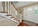 Bright foyer featuring a staircase with white banisters, hardwood floors, and a paneled front door at 104 Forest Point Ln, Longwood, FL 32779