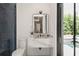 Modern bathroom featuring a floating vanity, stylish mirror, and walk-in shower with an outdoor view at 1211 Munster St, Orlando, FL 32803