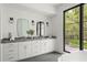 Bathroom featuring a dual vanity, a large window with views, and modern light fixtures at 1211 Munster St, Orlando, FL 32803