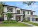 Modern two-story home featuring a manicured lawn, lush landscaping, and an attached two-car garage at 1211 Munster St, Orlando, FL 32803