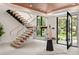 Elegant foyer featuring a modern staircase, light tile flooring, and a view of the front yard at 1211 Munster St, Orlando, FL 32803