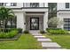 Inviting front entrance with a modern door, a well-manicured lawn, and lush landscaping at 1211 Munster St, Orlando, FL 32803