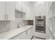 A modern, bright kitchen featuring custom white cabinetry, stainless steel appliances, and ample countertop space at 1211 Munster St, Orlando, FL 32803