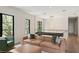 Open concept living area with leather sofa, accent chair, view of the modern staircase, and oversized black window frames at 1211 Munster St, Orlando, FL 32803