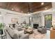Spacious living room features a marble fireplace, modern ceiling fan, and beautiful wooden tray ceiling at 1211 Munster St, Orlando, FL 32803
