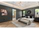 Dark-walled main bedroom with a luxurious bed, modern light fixture, and herringbone-patterned floor at 1211 Munster St, Orlando, FL 32803