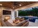Cozy outdoor living space with a wood ceiling, a fireplace, comfortable furniture, and a view of the pool at 1211 Munster St, Orlando, FL 32803