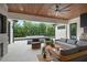 Stylish outdoor living space with modern furniture, a ceiling fan, and a tranquil view of the pool and lush landscaping at 1211 Munster St, Orlando, FL 32803