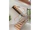 Modern staircase with floating wood steps, glass railings, and abundant natural light, creating an open and airy feel at 1211 Munster St, Orlando, FL 32803