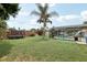 Large grassy yard with pool, trampoline, and brick garden, offering plenty of space for outdoor activities at 1360 Gladiolas Dr, Winter Park, FL 32792
