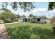 Charming single-story home with well-maintained lawn, palm trees, and stone accents, showcasing curb appeal at 1360 Gladiolas Dr, Winter Park, FL 32792
