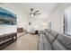 Bright living room featuring a large television, ceiling fan, and an open layout leading to the kitchen at 1360 Gladiolas Dr, Winter Park, FL 32792