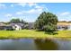 Backyard view of this home next to a pond with screened-in porch and lush green grass at 14377 Lord Barclay Dr, Orlando, FL 32837