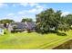 Spacious backyard featuring a lush green lawn, mature trees, and a screened lanai at 14377 Lord Barclay Dr, Orlando, FL 32837