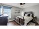 Cozy bedroom featuring a dark wood bed frame, wood floors, and a window with blinds at 14377 Lord Barclay Dr, Orlando, FL 32837