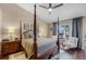 Spacious bedroom featuring a four-poster bed, wood floors, and a cozy seating area by the window at 14377 Lord Barclay Dr, Orlando, FL 32837