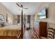 Bright bedroom boasts a four-poster bed, ceiling fan, wood floors, and a wall-mounted television at 14377 Lord Barclay Dr, Orlando, FL 32837