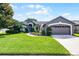Charming single-story home with lush landscaping and a well-manicured front yard at 14377 Lord Barclay Dr, Orlando, FL 32837