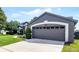Attached two-car garage with a paved driveway and manicured landscaping at 14377 Lord Barclay Dr, Orlando, FL 32837