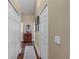 Hallway featuring white doors, wood floors, neutral walls, and a decorative rug at 14377 Lord Barclay Dr, Orlando, FL 32837