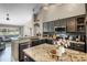 Spacious kitchen with granite countertops, stainless steel appliances, and dark cabinets, open to the living area at 14377 Lord Barclay Dr, Orlando, FL 32837