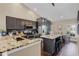 A gourmet kitchen features granite counters, dark cabinetry, stainless appliances, and a central island with seating at 14377 Lord Barclay Dr, Orlando, FL 32837
