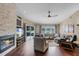 Bright living room with a stone fireplace, hardwood floors, and sliding glass doors leading to a pool area at 14377 Lord Barclay Dr, Orlando, FL 32837