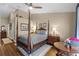 Cozy main bedroom with hardwood floors, neutral walls, and a four-poster bed, offering a relaxing retreat at 14377 Lord Barclay Dr, Orlando, FL 32837