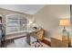 A bright home office with white shutters, wood floors, a stylish desk, and a beige color scheme makes working from home easy at 14377 Lord Barclay Dr, Orlando, FL 32837