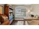 A home office is bright with natural light from the window and has a wooden desk and bookshelf for storing all your essentials at 14377 Lord Barclay Dr, Orlando, FL 32837