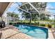 This screened-in backyard pool is bordered with a brick patio and lush landscaping, providing a private space to relax and unwind at 14377 Lord Barclay Dr, Orlando, FL 32837