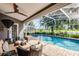 The screened-in backyard pool is bordered with a brick patio, lush landscaping, and tranquil lake views for the ultimate outdoor experience at 14377 Lord Barclay Dr, Orlando, FL 32837