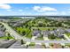 Beautiful aerial view of a serene community featuring lush green spaces, manicured lawns, and a tranquil lake in the distance at 14880 Ellingsworth Ln, Winter Garden, FL 34787