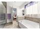 Luxurious main bathroom featuring a soaking tub, separate shower, and access to the main bedroom at 14880 Ellingsworth Ln, Winter Garden, FL 34787