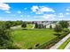 This aerial shows a grassy common area with a walking path, benches, and landscaping at 14880 Ellingsworth Ln, Winter Garden, FL 34787