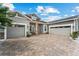 Attractive home exterior with a brick driveway, three-car garage, and well-maintained landscaping at 14880 Ellingsworth Ln, Winter Garden, FL 34787