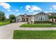 Charming gray single-story home with a well-manicured lawn and a brick driveway at 14880 Ellingsworth Ln, Winter Garden, FL 34787