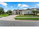 Charming single-Gathering home showcasing lush landscaping, brick driveway, and a welcoming front porch at 14880 Ellingsworth Ln, Winter Garden, FL 34787