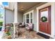 Inviting front porch with seating, a decorative wreath, and stone accents at 14880 Ellingsworth Ln, Winter Garden, FL 34787